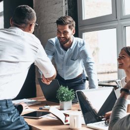 Young-modern-men-in-smart-casual-wear-shaking-hands-and-smiling-while-working-in-the-creative-office-how-to-introduce-yourself